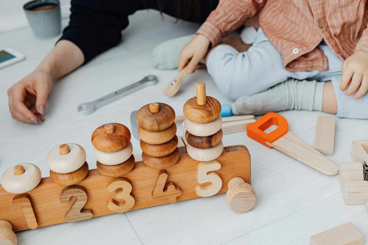 Mamma con un bambino: gioco sul pavimento